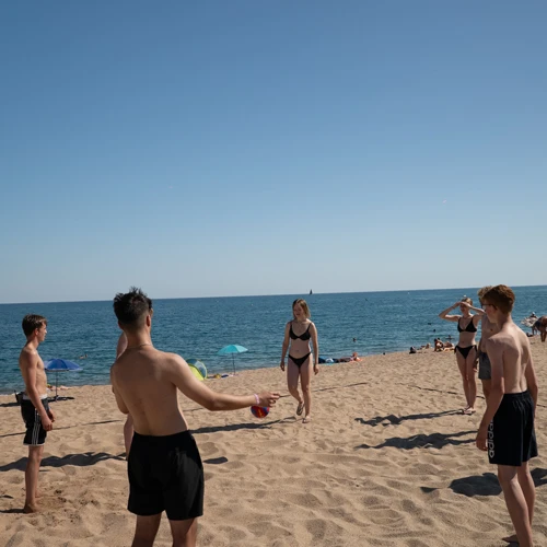 Junge Menschen spielen Ball am Strand von Margrat de Mar.