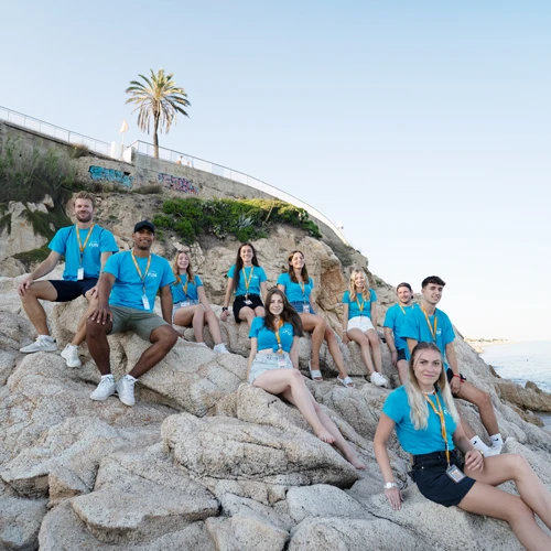 Junge Menschen sitzen auf einem Panorama-Felsen in Spanien.