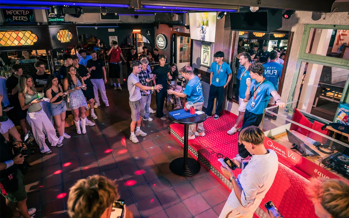 Jugendliche spielen abends gemeinsam ein interaktives Spiel in einer Bar auf einer FUN-Jugendreise 2026.
