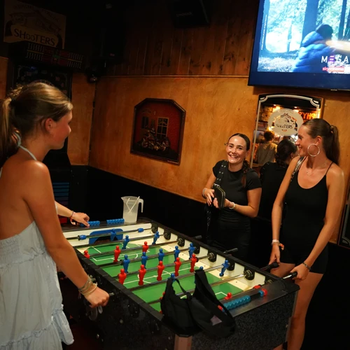 Drei junge Frauen beim Kickern im Urlaub