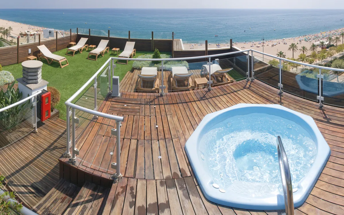 Eine sonnige Dachterrasse mit einem Whirlpool (Jacuzzi) und weitem Panoramablick über Calella.