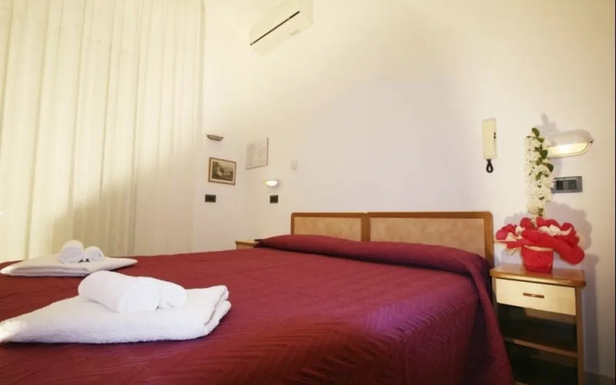 Doppelzimmer im Hotel Zurigo mit roter Bettdecke und weißen Handtüchern