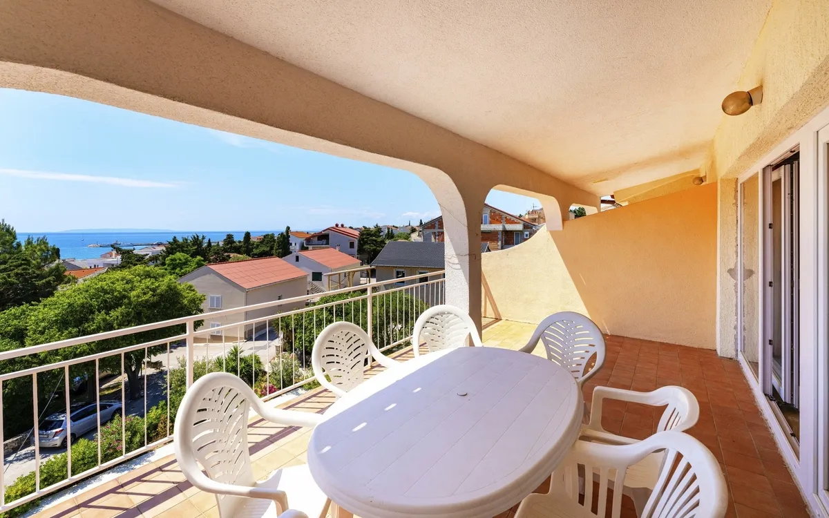 Überdachter Balkon mit Sitzgelegenheiten (Tisch und Stühle), ideal für den Start in die Partynacht in Kroatien.