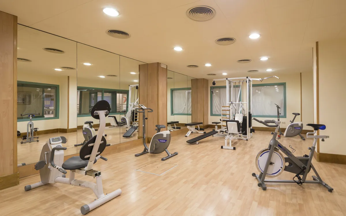 Ein voll ausgestatteter Fitnessraum mit Kardiogeräten und Kraftstationen für das tägliche Workout.