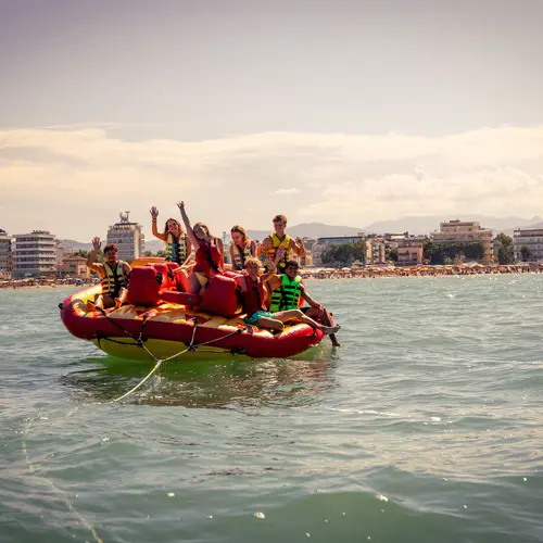 Junge Leute auf einem gezogenem Gummiboot vor Rimini.